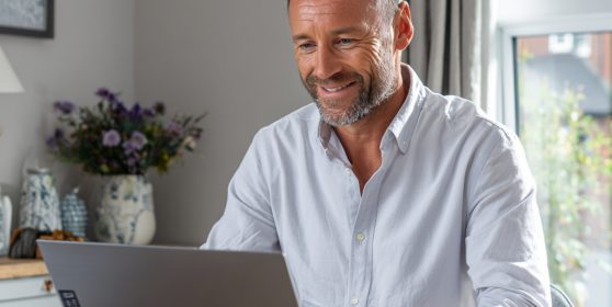 Man completing online loan application on laptop